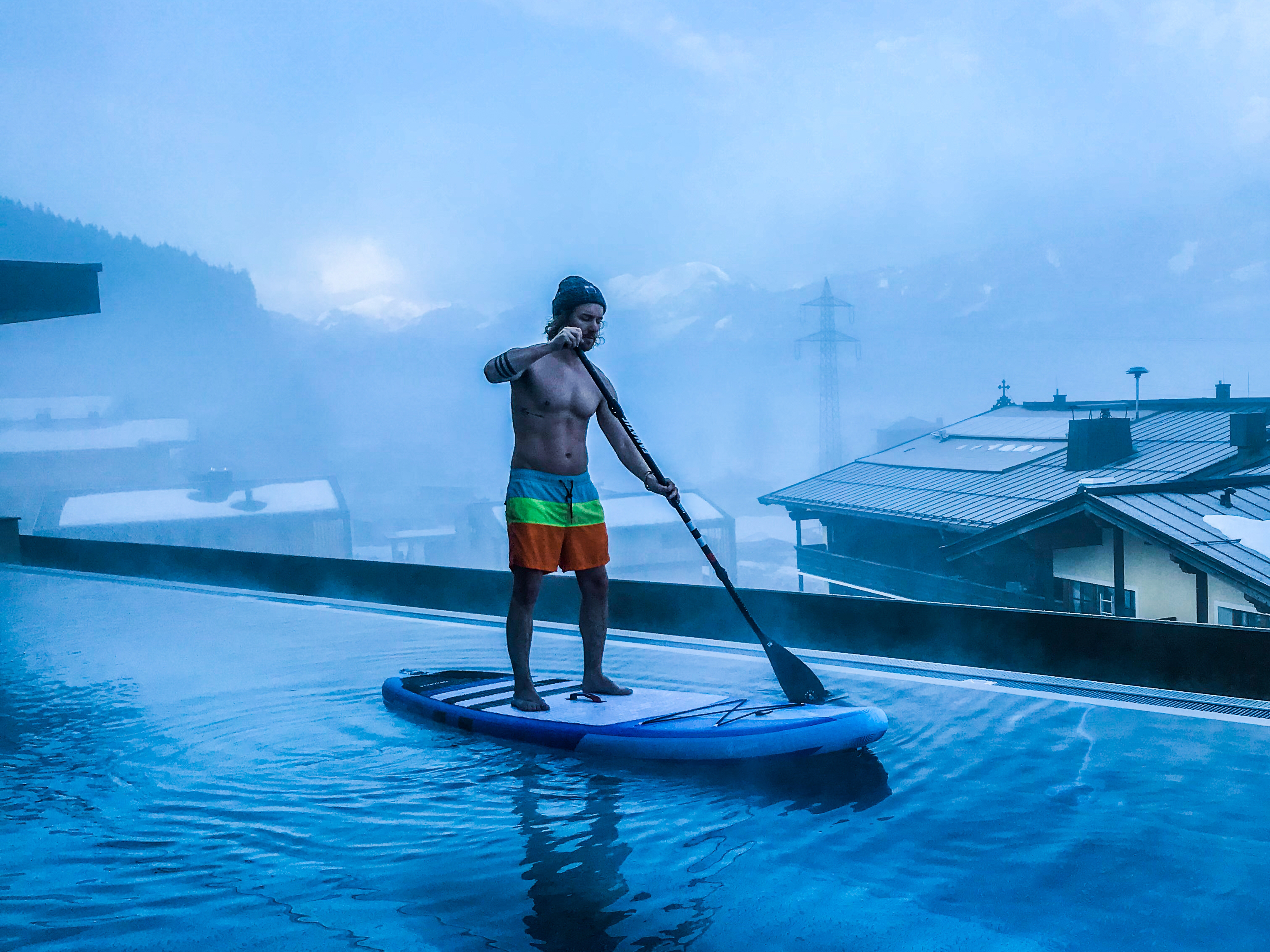 Paddeln aufm Dach: Früh morgens beim Stand Up Paddeln auf dem Infinity Pool eines Hotels in Tirol (Österreich). Paddeln aufm Dach: Früh morgens beim Stand Up Paddeln auf dem Infinity Pool eines Hotels in Tirol (Österreich).