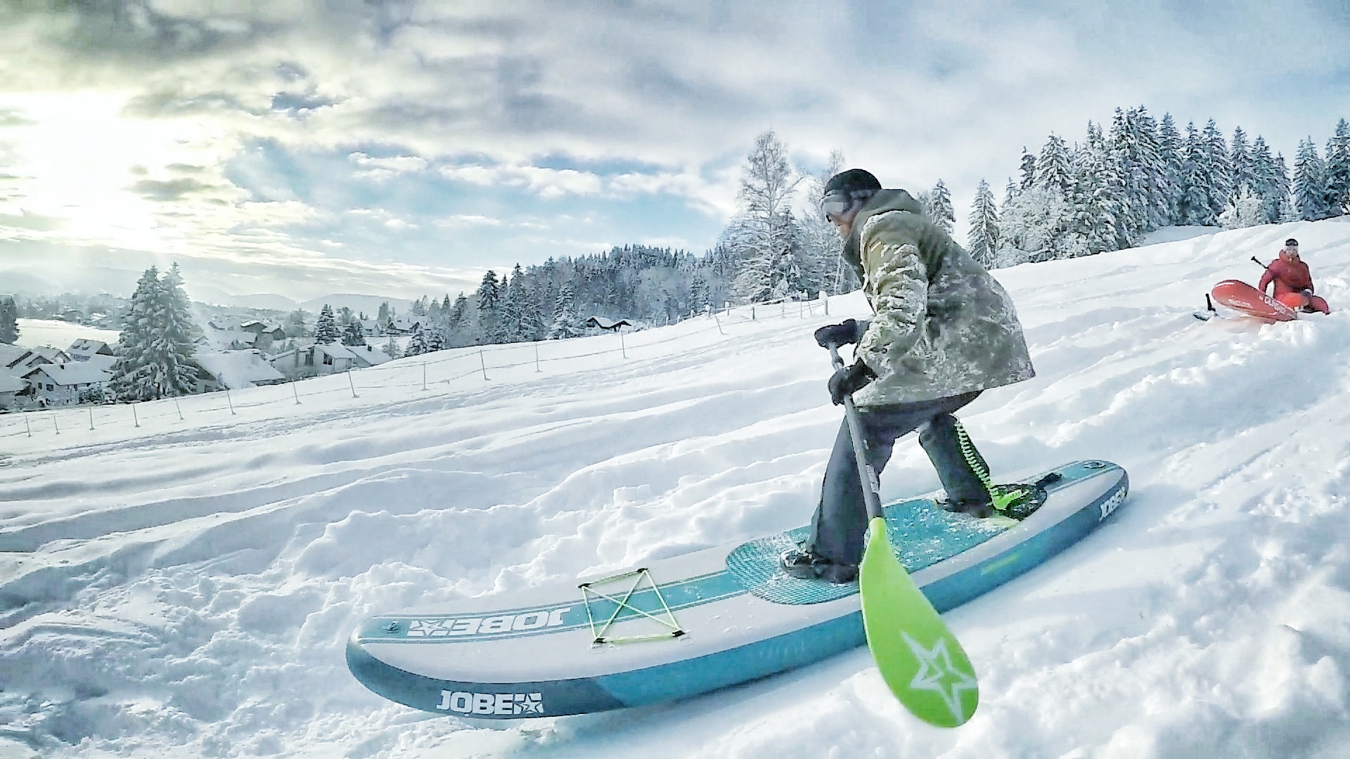 Wer braucht schon Wasser? Fürs SUP-Snowboarding braucht's nur einen Hügel, Schnee und ein bisserl Mut.